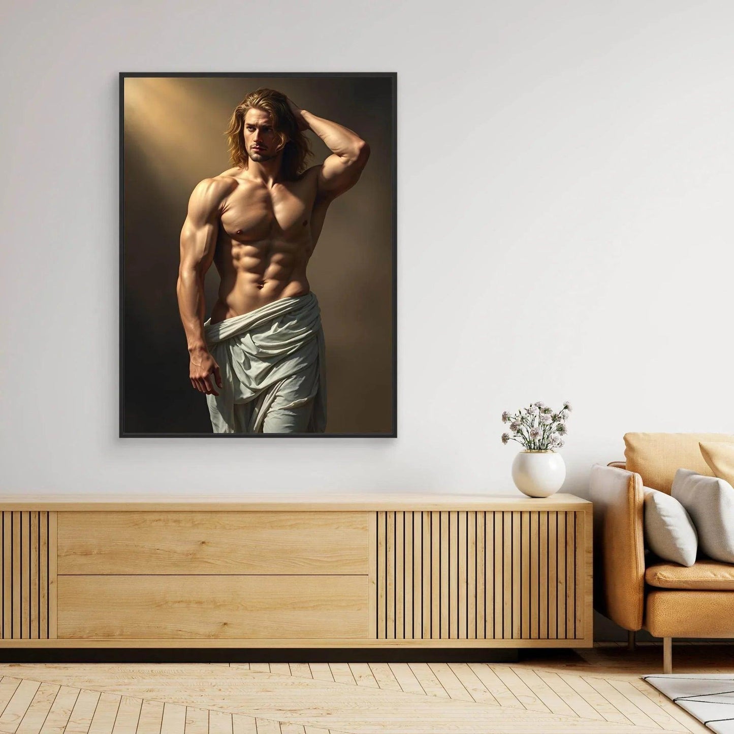 Black-framed portrait print of shirtless long-haired man with light draped cloth at waist.