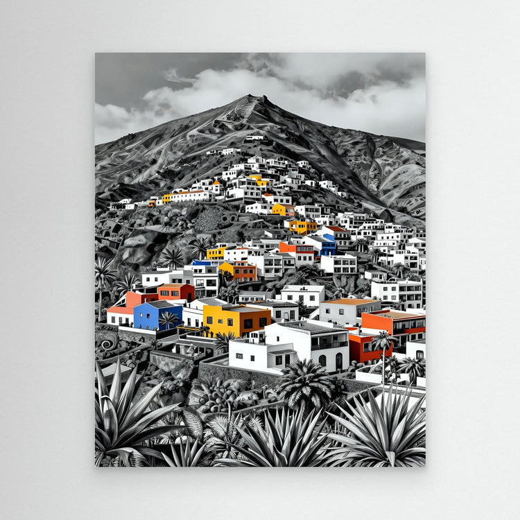Black-framed wall art print with colorful buildings, a mountain peak, and large spiky plants