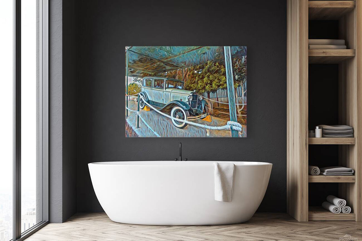 Framed print of a vintage blue car scene above a white bathtub, with fence and trees.